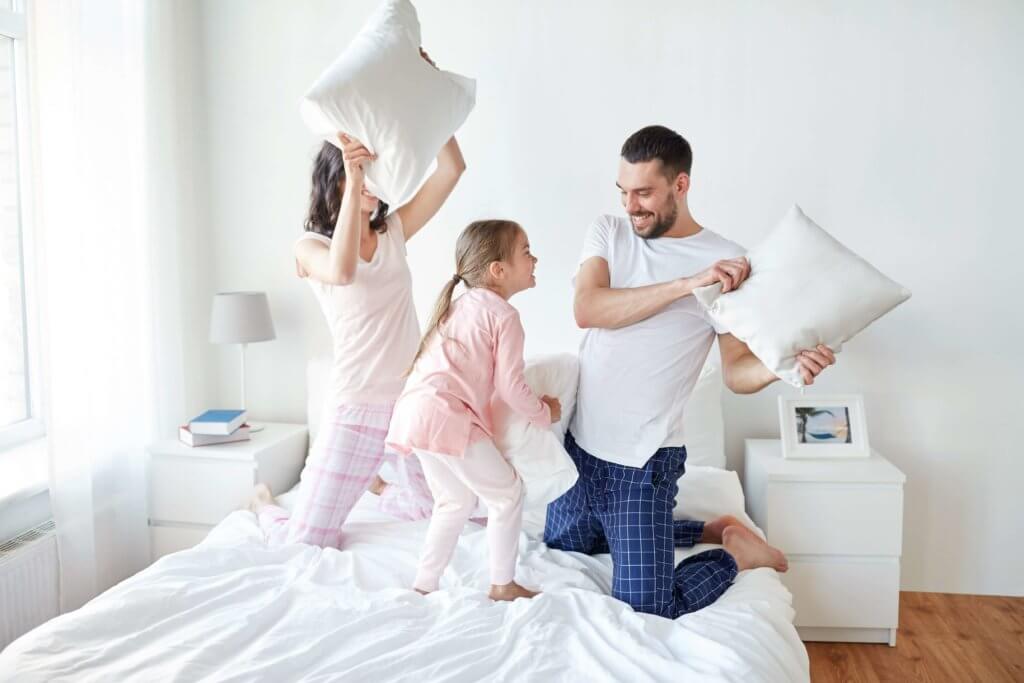 Family on their bed having a pillow fight