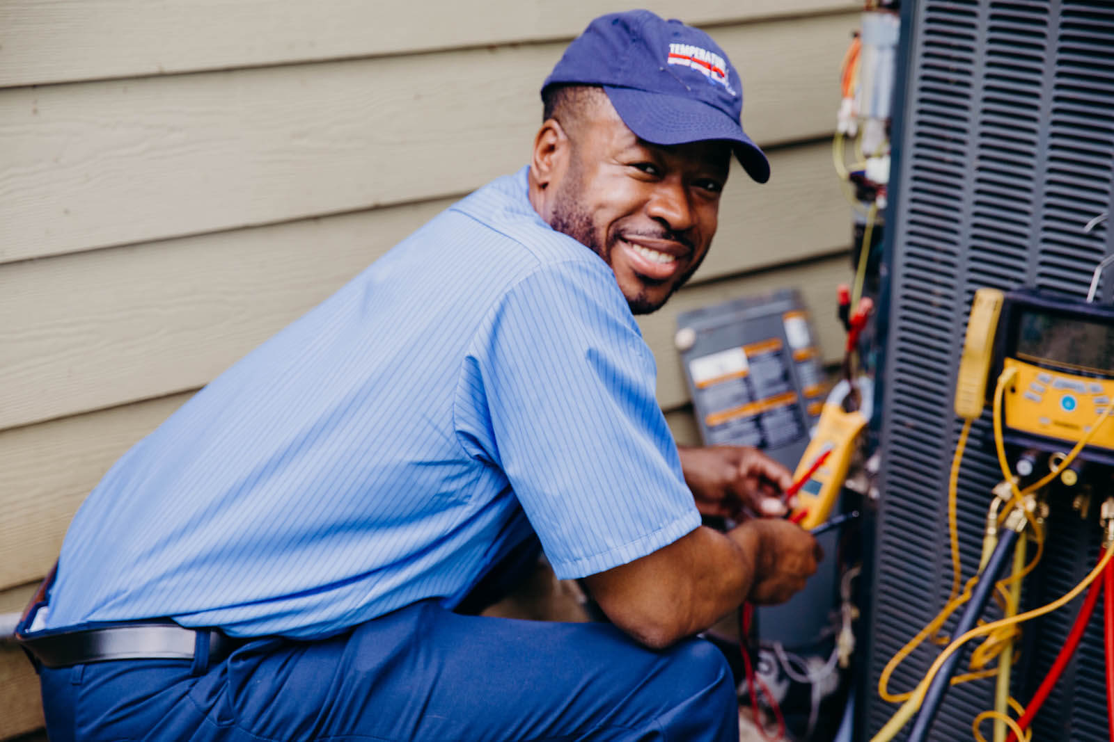 hvac technician working on outdoor heating and cooling unit