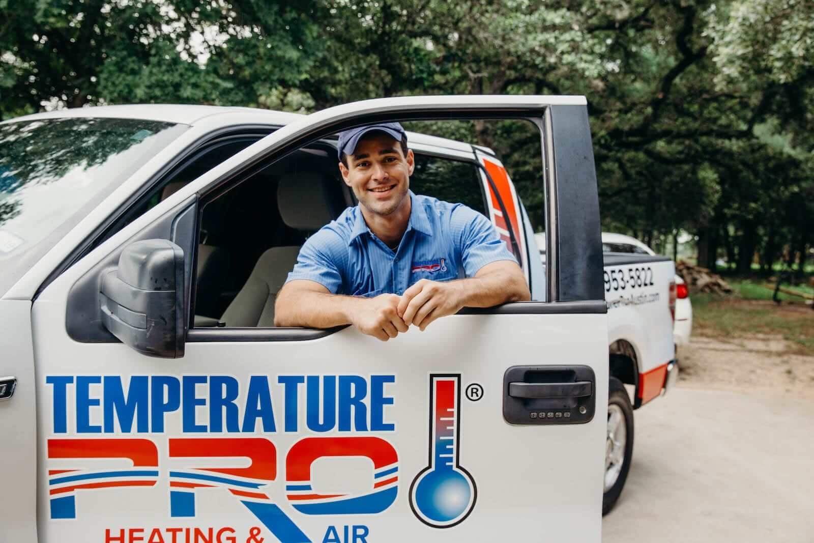 hvac technician standing with his truck
