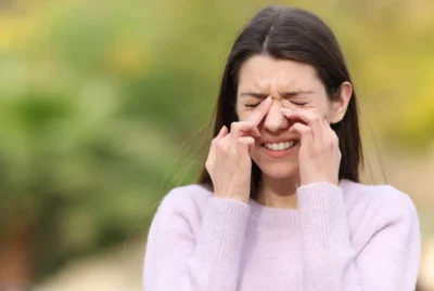 Person struggling with allergies in Austin is rubbing her itchy eyes,