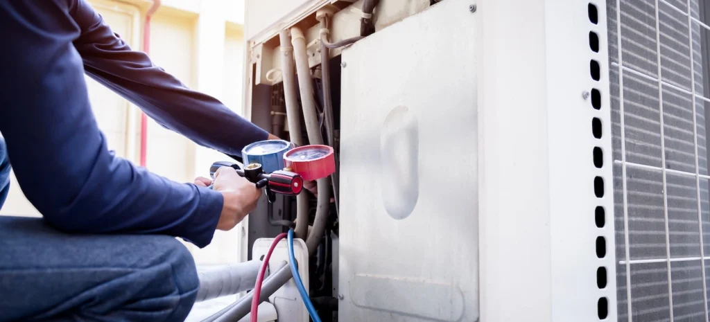 HVAC technician checking on an outdoor heat pump unit